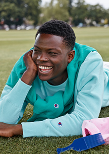 man smiling while wearing champion product