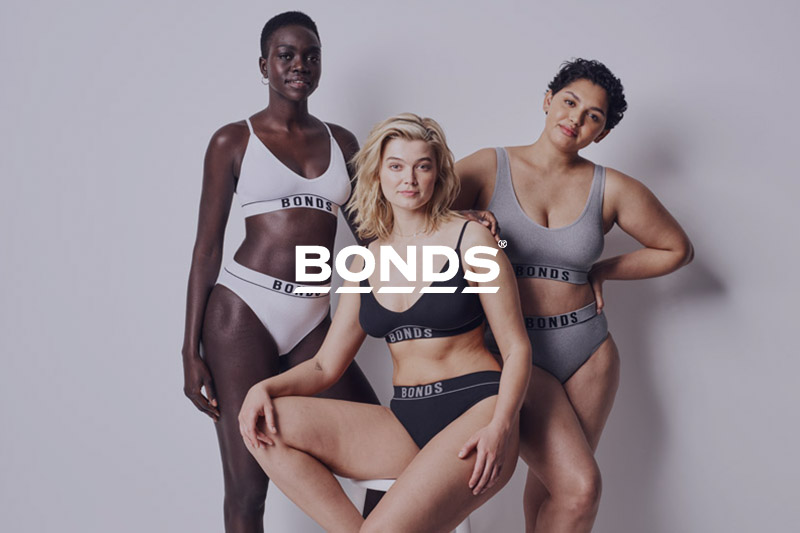 Three women wearing Bonds product and the Bonds logo